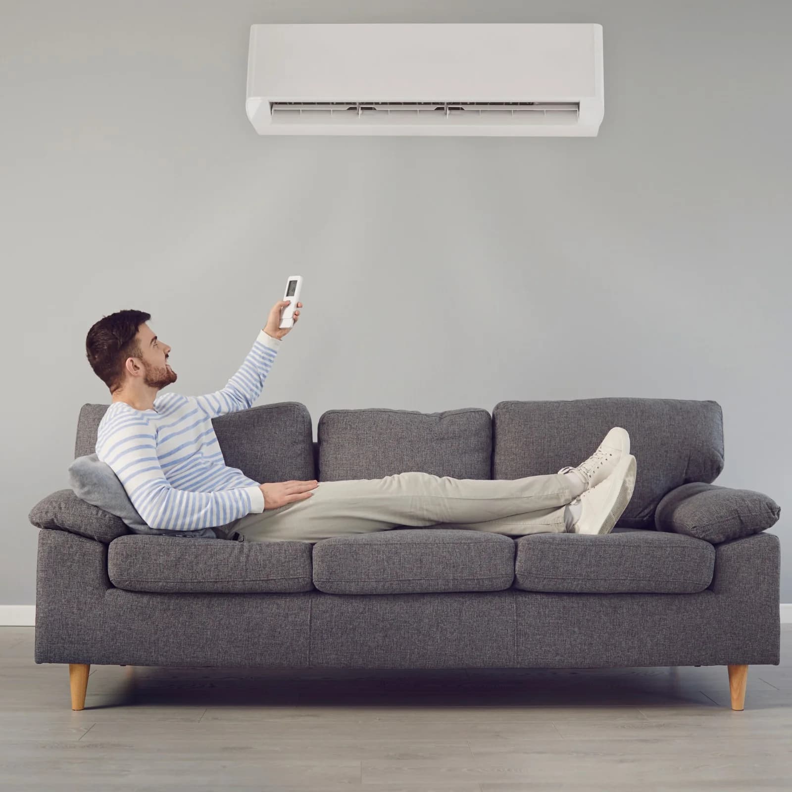 Homeowner relaxing under a wall-mounted heat pump