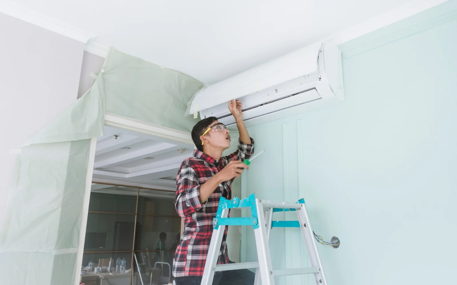 Triple A Plaza technician installing a heat pump head unit