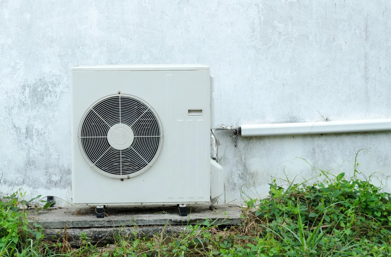 Bomba de calor exterior instalada junto a una vivienda